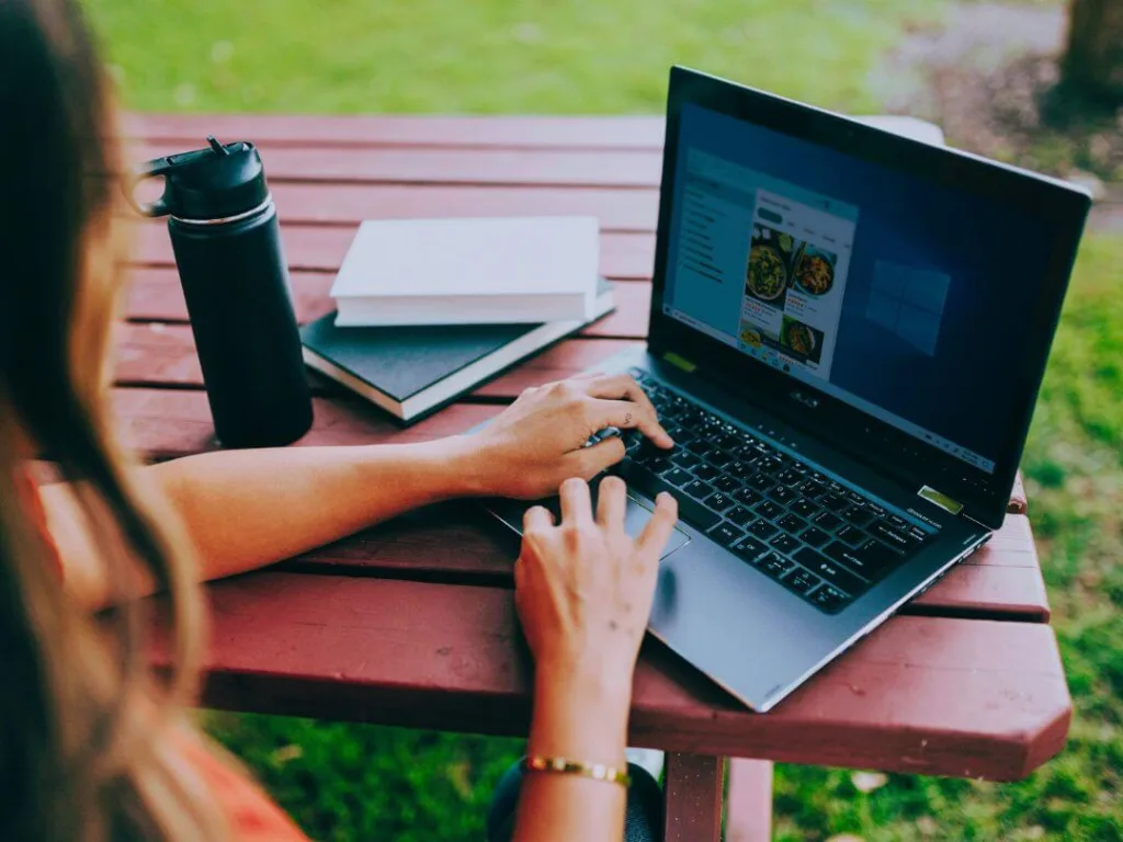 Person on laptop working on a magazine page layout design.