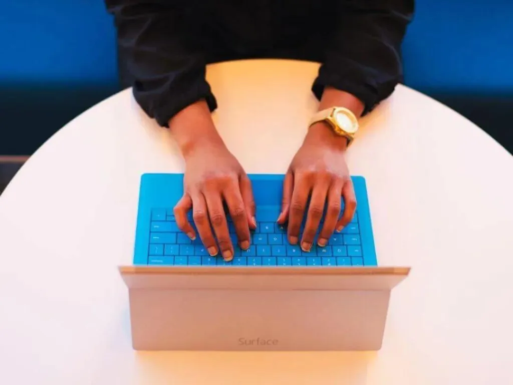 Person using laptop on desk for email marketing.